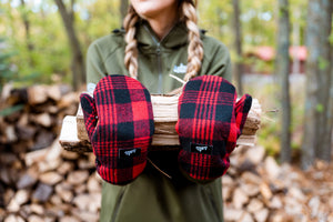 woman carrying firewood with cozy minnesota mittens.
