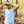 Man wearing a light blue t-shirt with a logo in a forest setting
