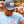 Person wearing a gray cap with a loon logo and a light blue t-shirt with a red minnesota logo in a forest setting