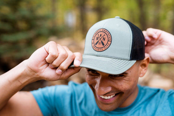 Person wearing a cap with a Minnesota logo in a forest setting