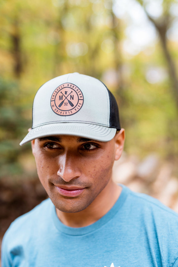 Person wearing a cap with a Minnesota logo in a forest setting